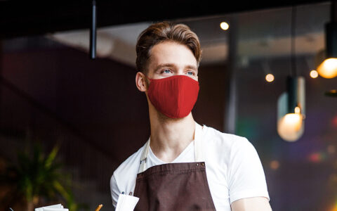 a restaurant server wearing a red face mask