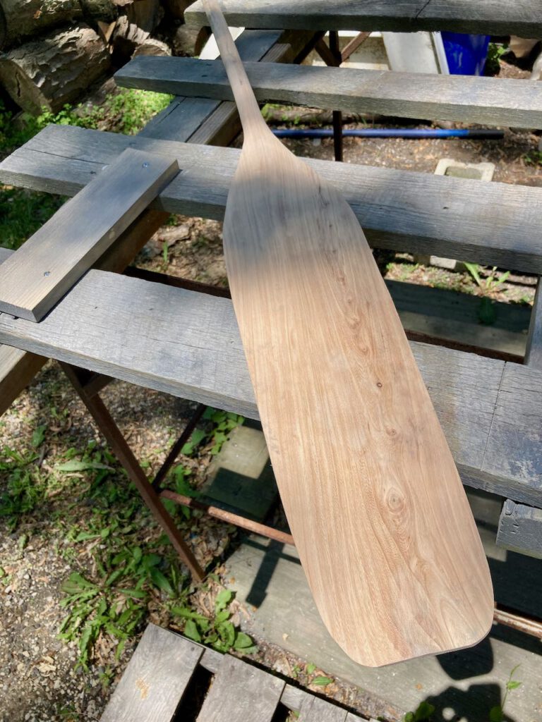 partially shaped otter tail paddle on a workbench