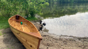 wooden cedar strip canoe on the shore of a river