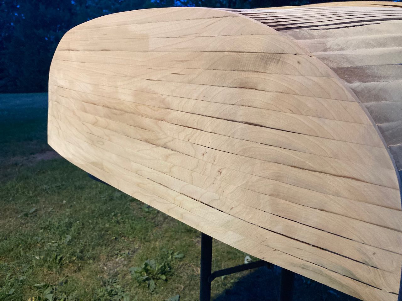 Wooden boat under construction. The aft is fully assembled and rough sanding is in process. This view highlights the grain pattern of the cherry strips.
