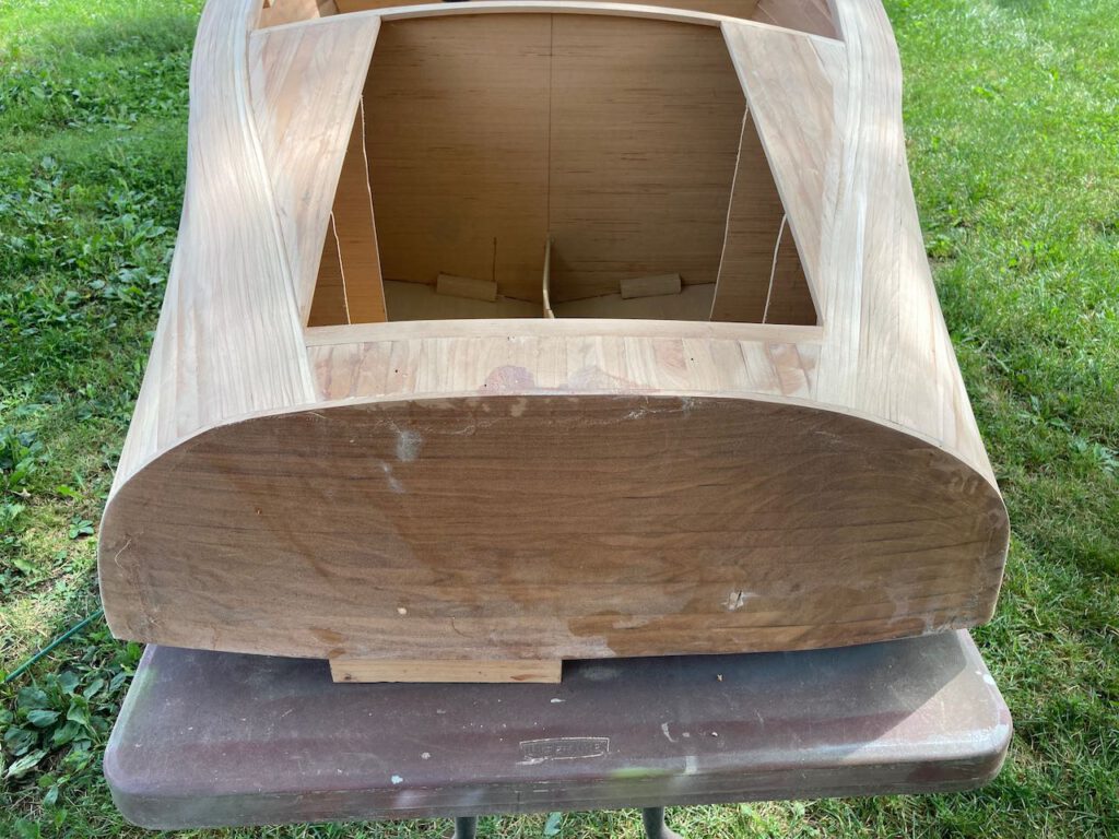Small boat under construction. A view of the stern of the boat highlighting finish sanding nearly complete.