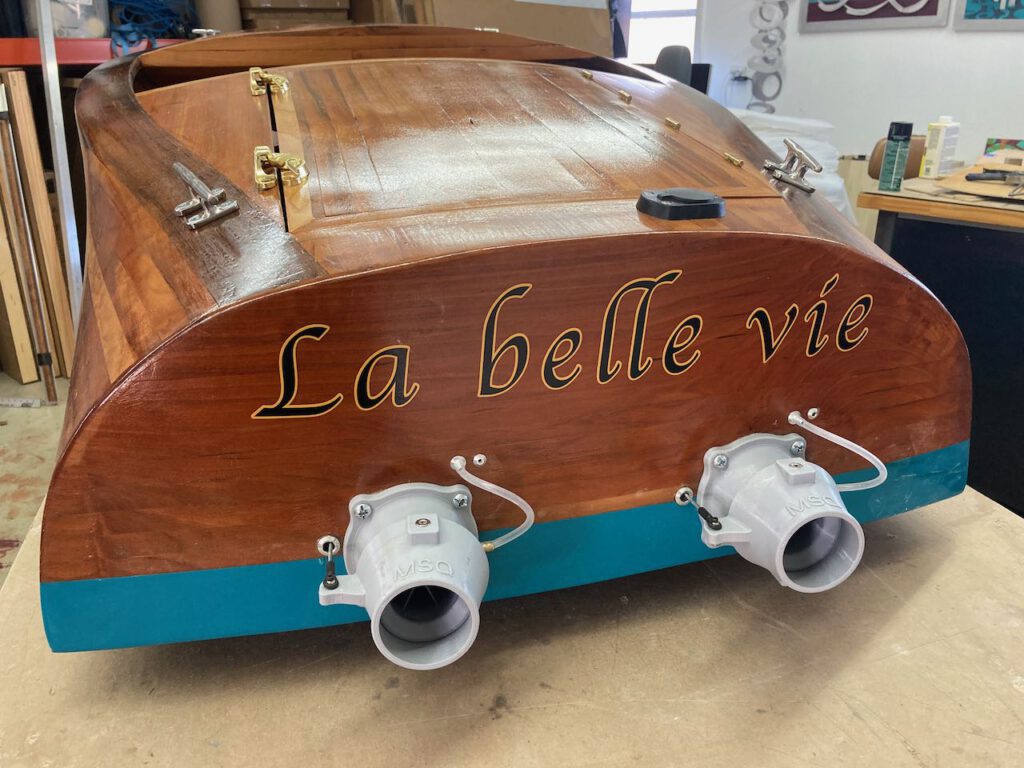The finished boat receives its name decal. This photograph of the stern shows the boat's name, la belle vie.